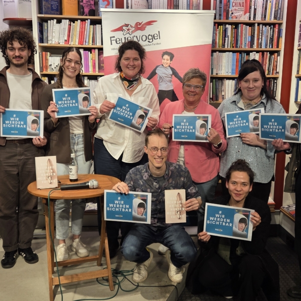 Die Veranstalter und die Autorin (7 Personen) halten ein Plakat mit dem Motto "Wir werden sichtbar" hoch.
